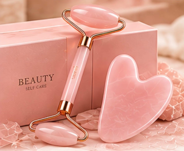 Pink facial roller and gua sha tool beside pink packaging