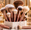 Rose-gold makeup brushes displayed in a marble holder